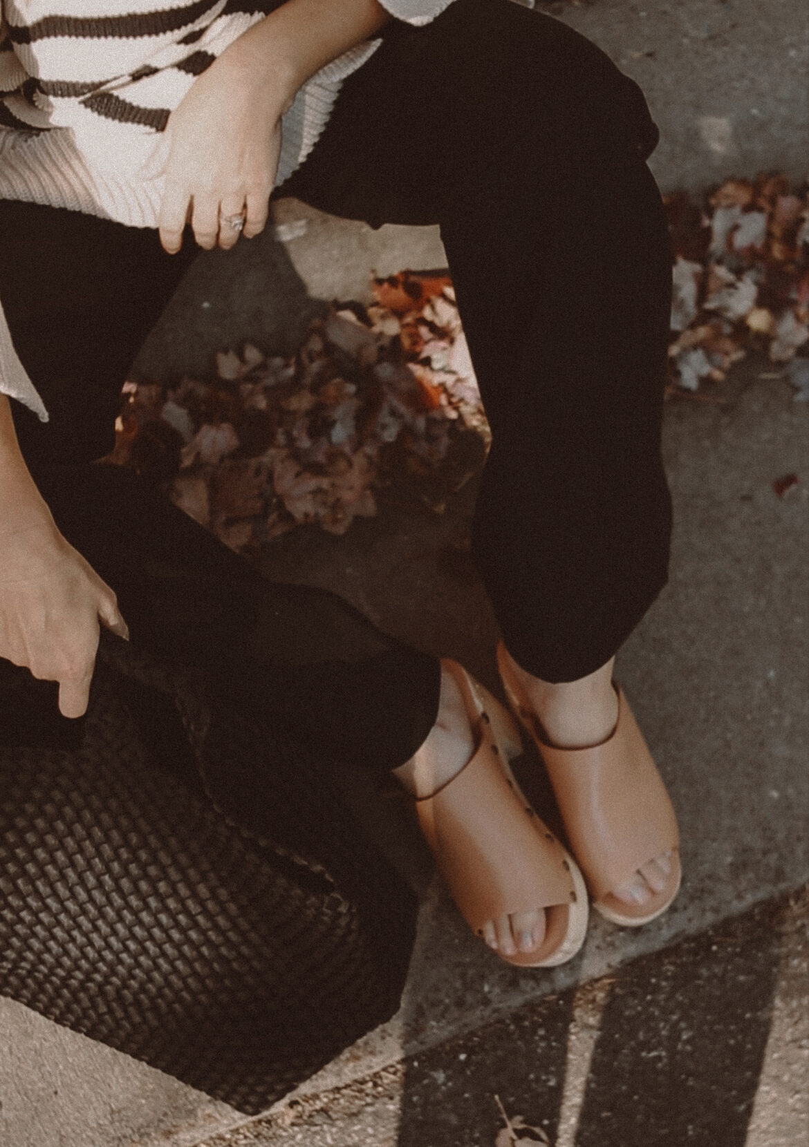 Karin Emily wears a pair of wooden blogs and black wide leg pants