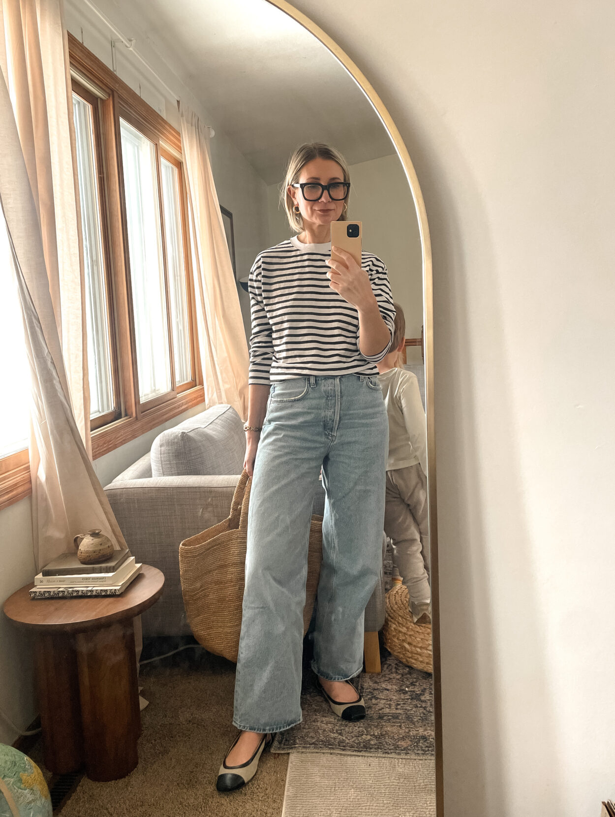 Karin Emily shares a mirror selfie wearing a striped shirt, baggy agolde jeans and two tone flats