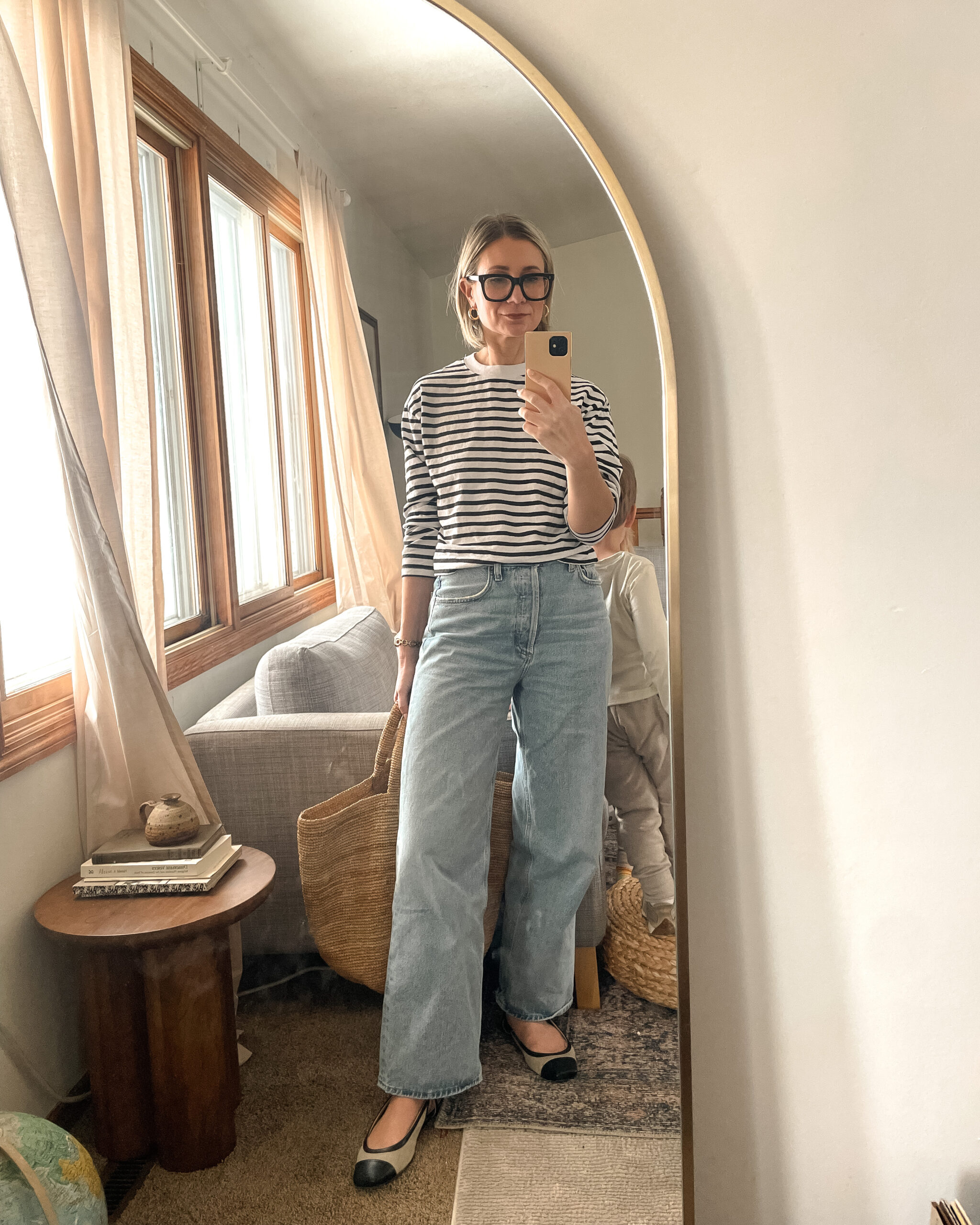 Karin Emily shares a mirror selfie wearing a striped shirt, baggy agolde jeans and two tone flats