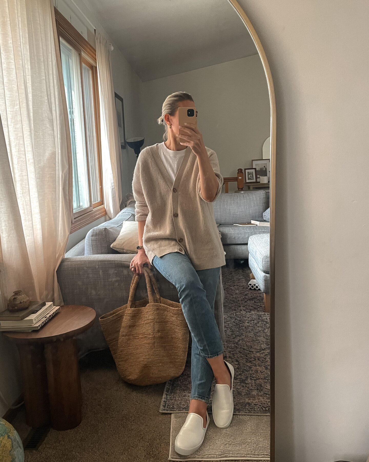 Karin Emily shares a mirror selfie wearing a jenni kayne cashmere cocoon cardigan, straight leg jeans, and freda salvador eddy sneakers