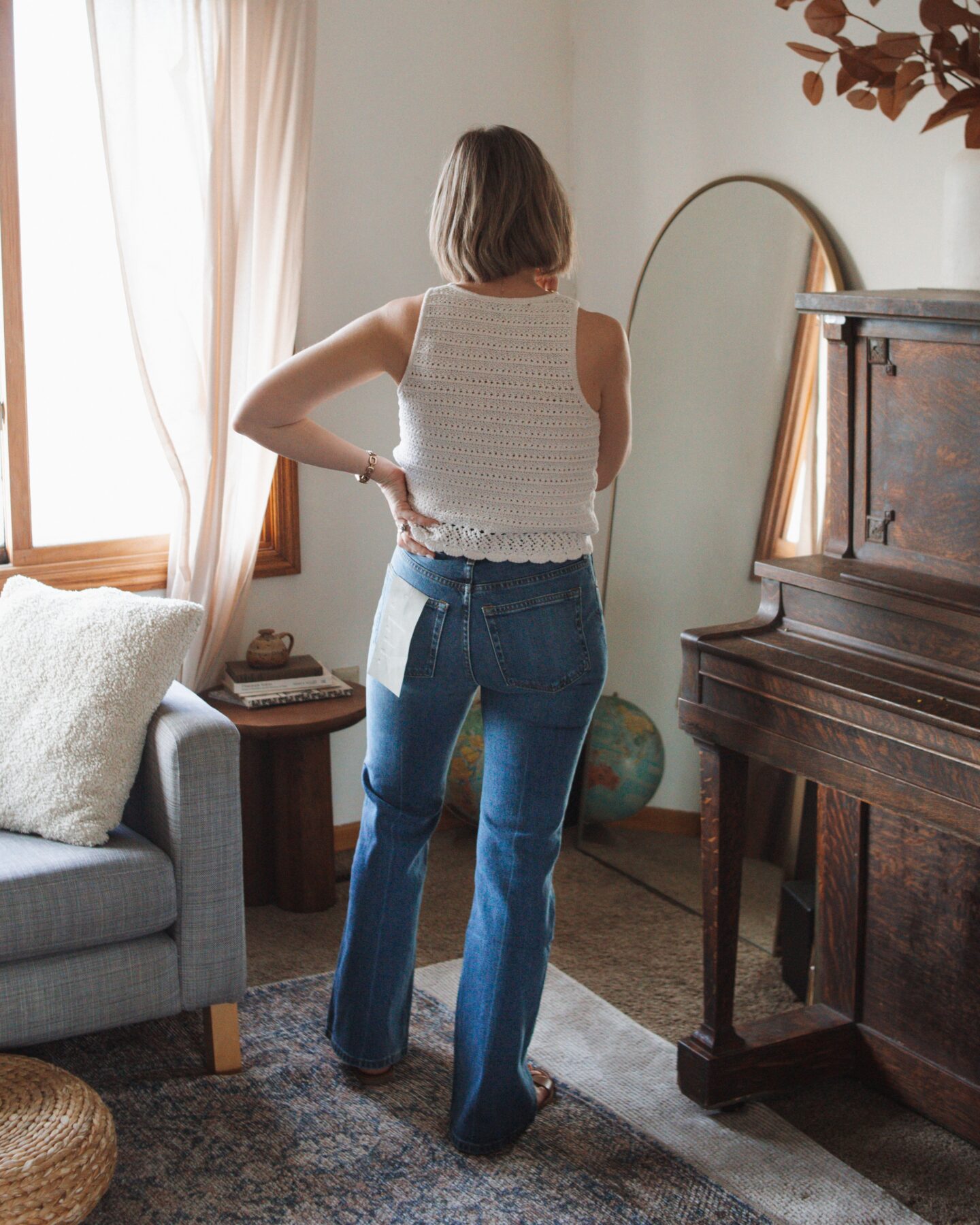 Karin Emily wears the new Everlane flare denim while standing in her living room