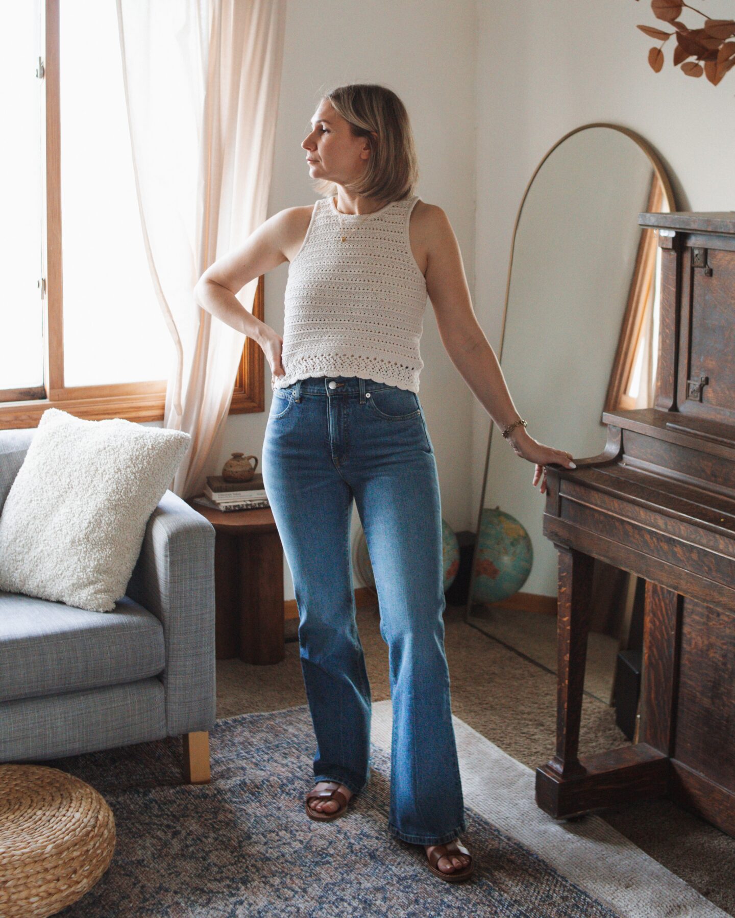 Karin Emily wears the new Everlane flare denim while standing in her living room