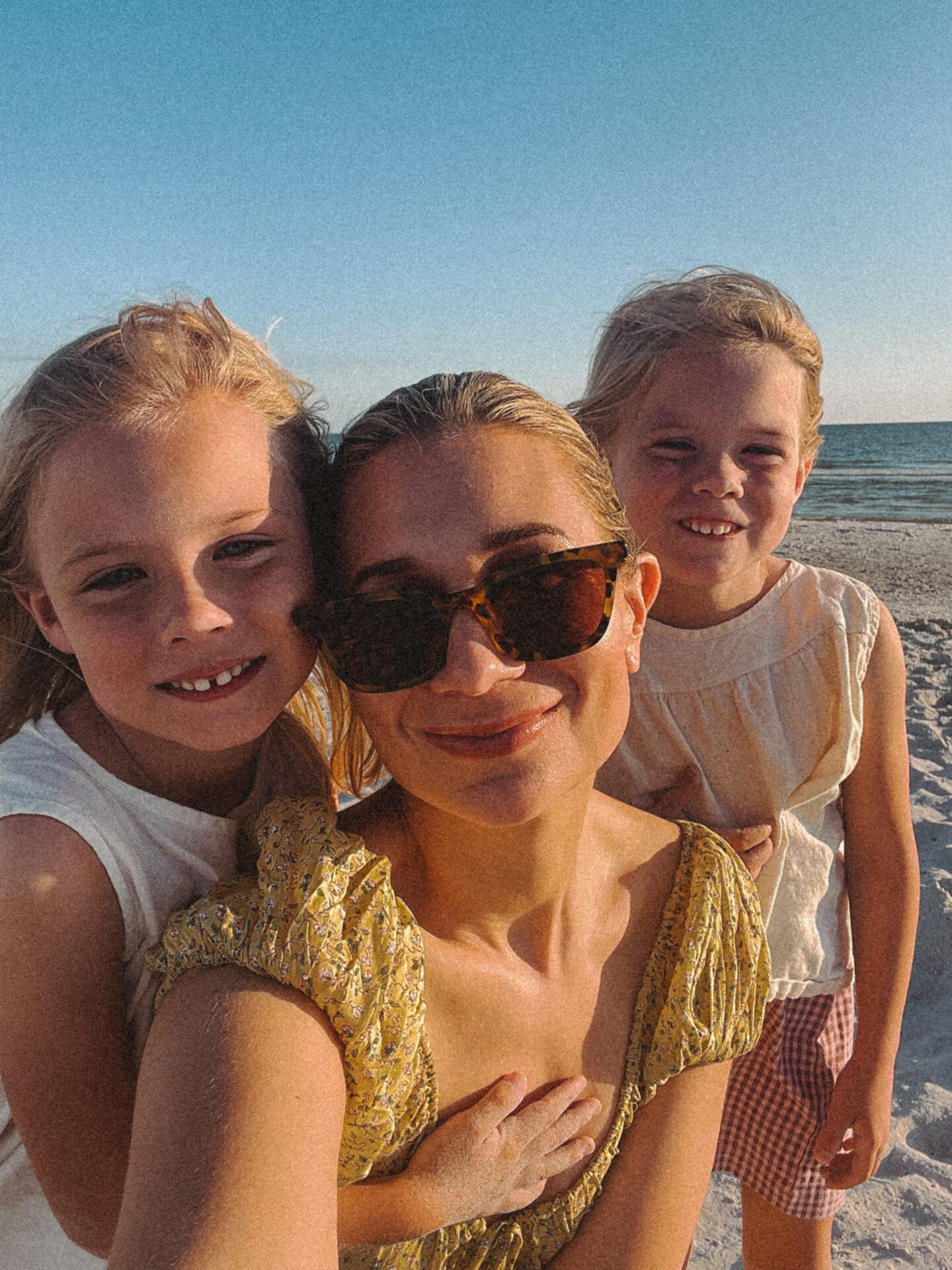 Karin Emily takes a selfie with her twin daughters on the beach