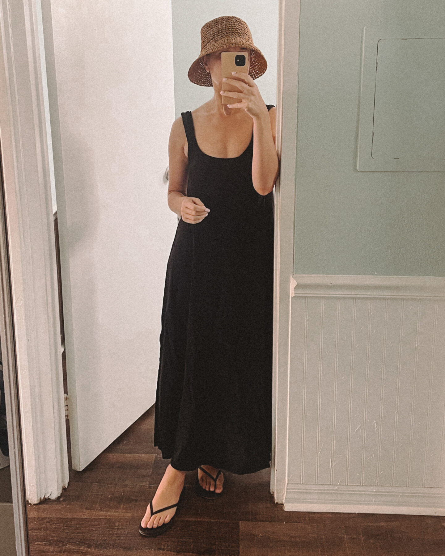 Karin Emily takes a mirror selfie wearing a long black swimsuit coverup