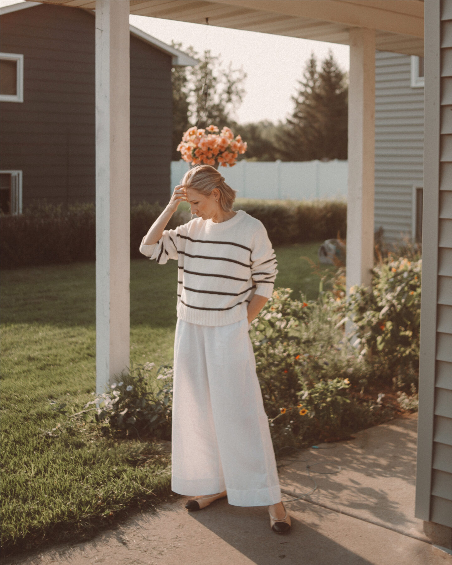 Karin Emily wears a striped Jenni Kayne sweater, white wide, leg pants and black cap toe flats