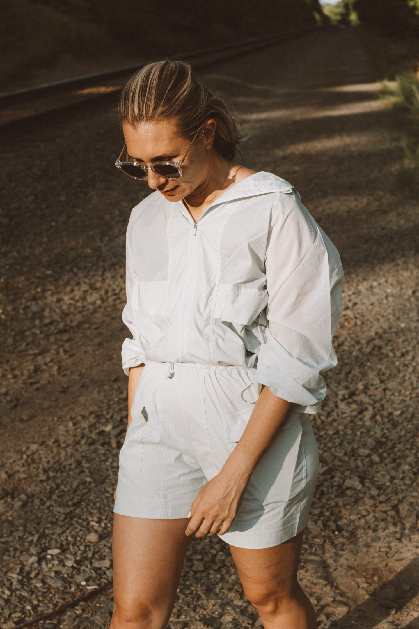 Karin Emily wears a hiking set from NEIWAI while standing in front of an outdoor wooded area