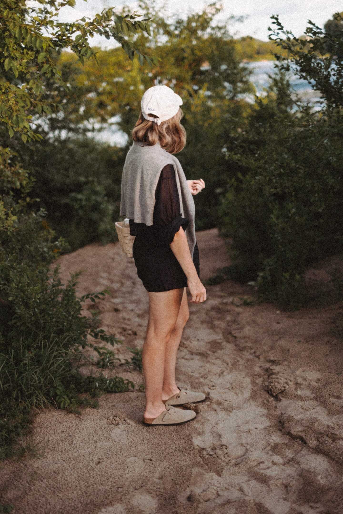 Karin Emily stands with in front of a beach path and wears the Jana top from the pre fall at Doen collection 