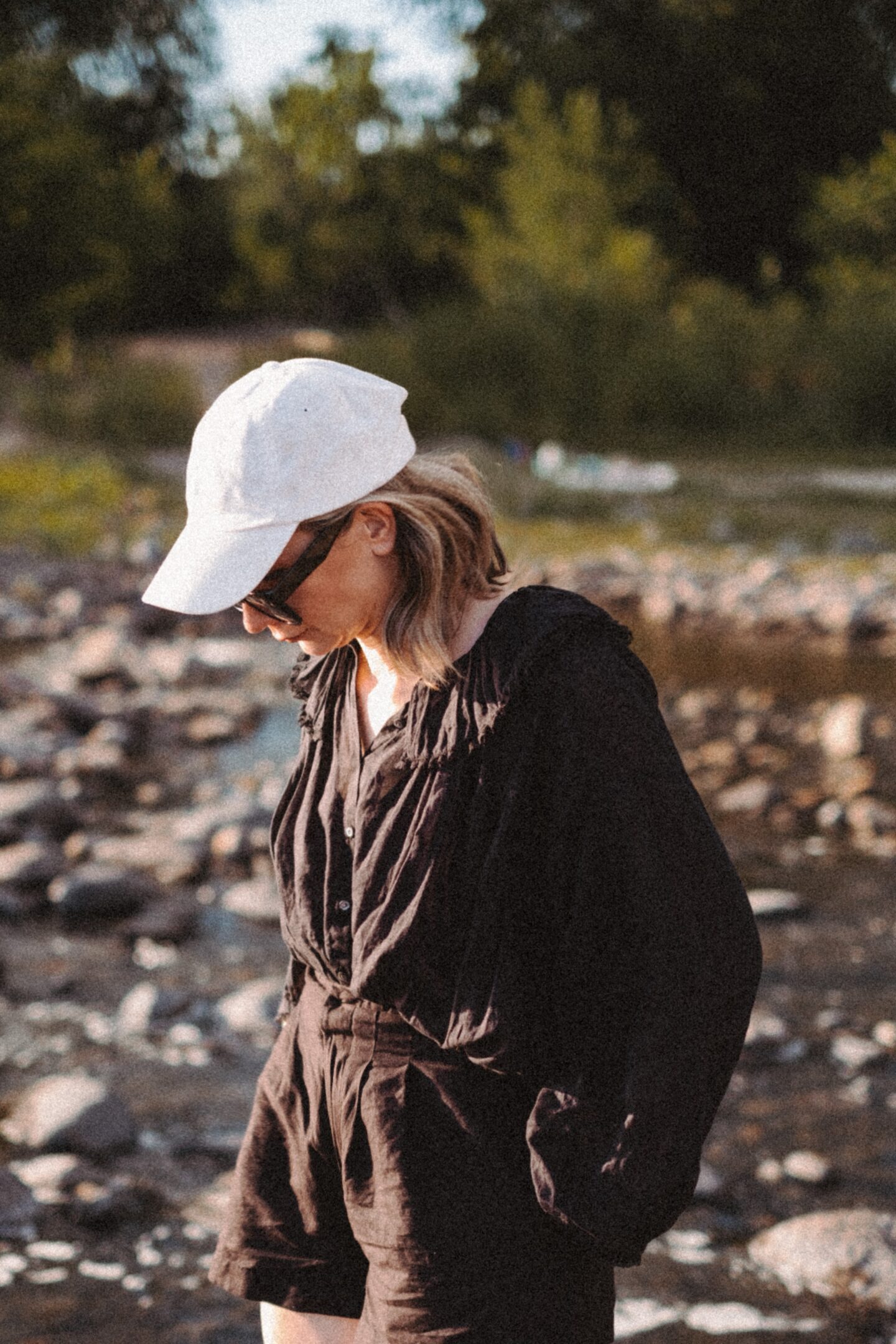 Karin Emily stands with in front of a rocky river bed and wears the Jana top from the pre fall at Doen collection 