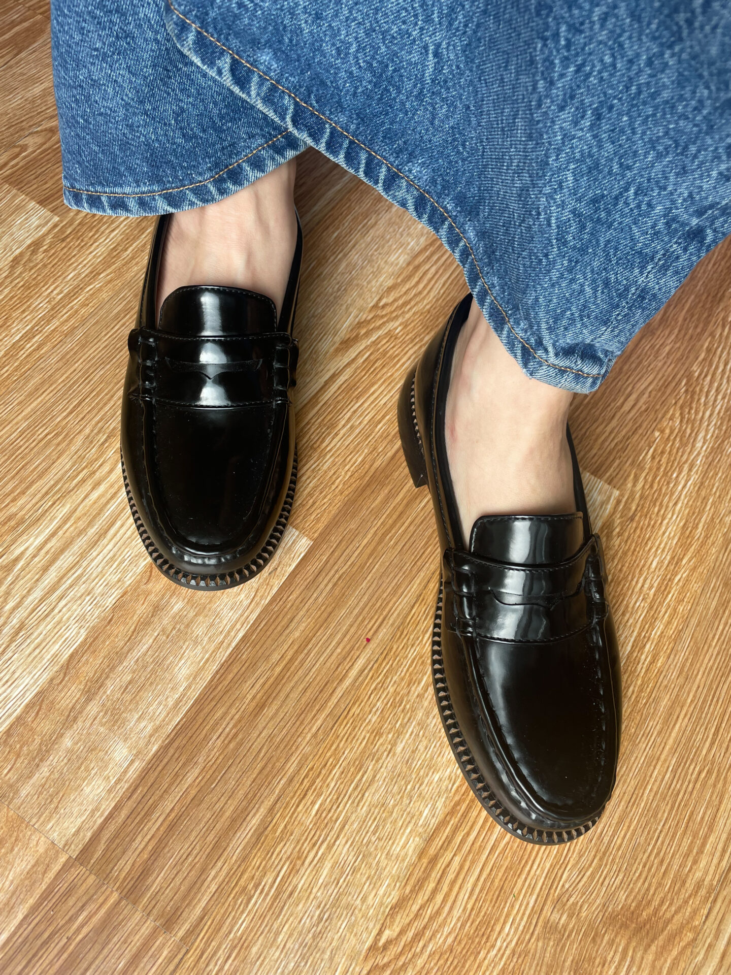 Karin Emily ears a pair of black patent Elba penny loafers from Freda Salvador 