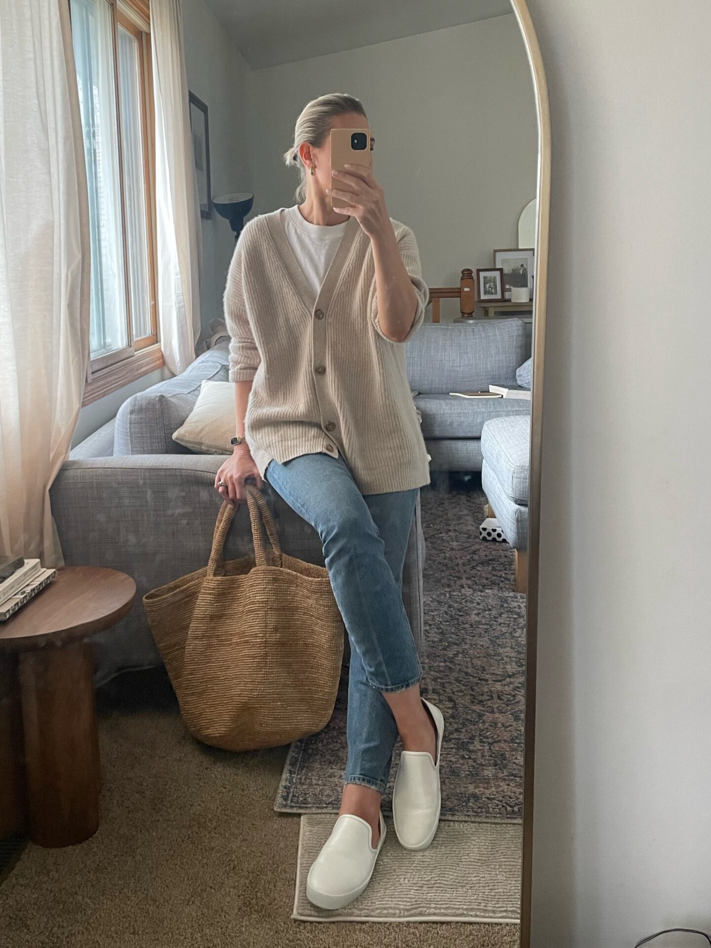 Karin Emily wears a cashmere cardigan with jeans and white sneakers