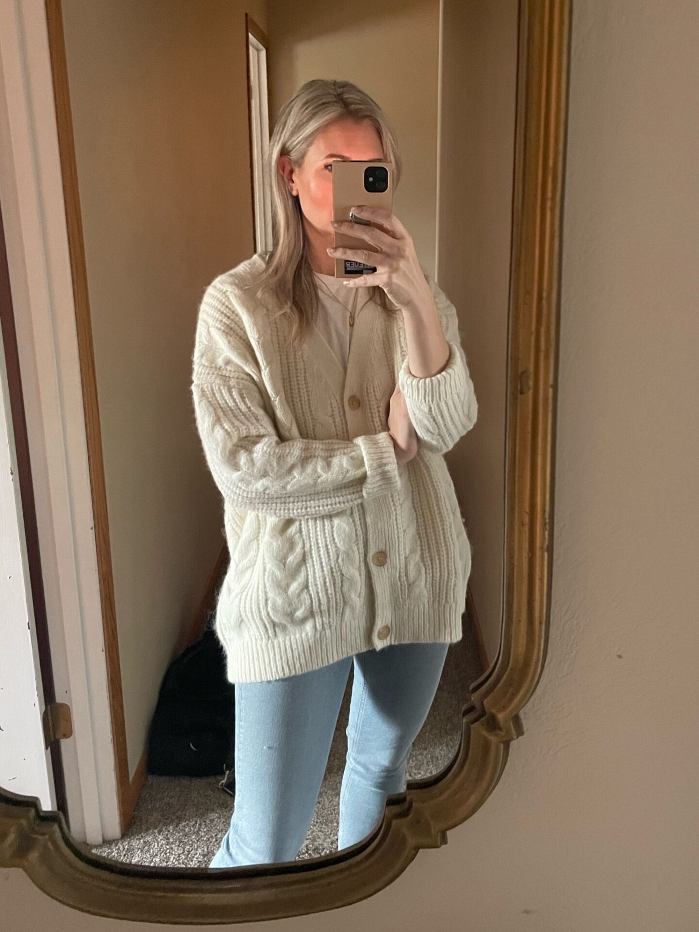 Karin Emily wears a chunky cable knit cable knit cardigan that is on sale for Black Friday Sales