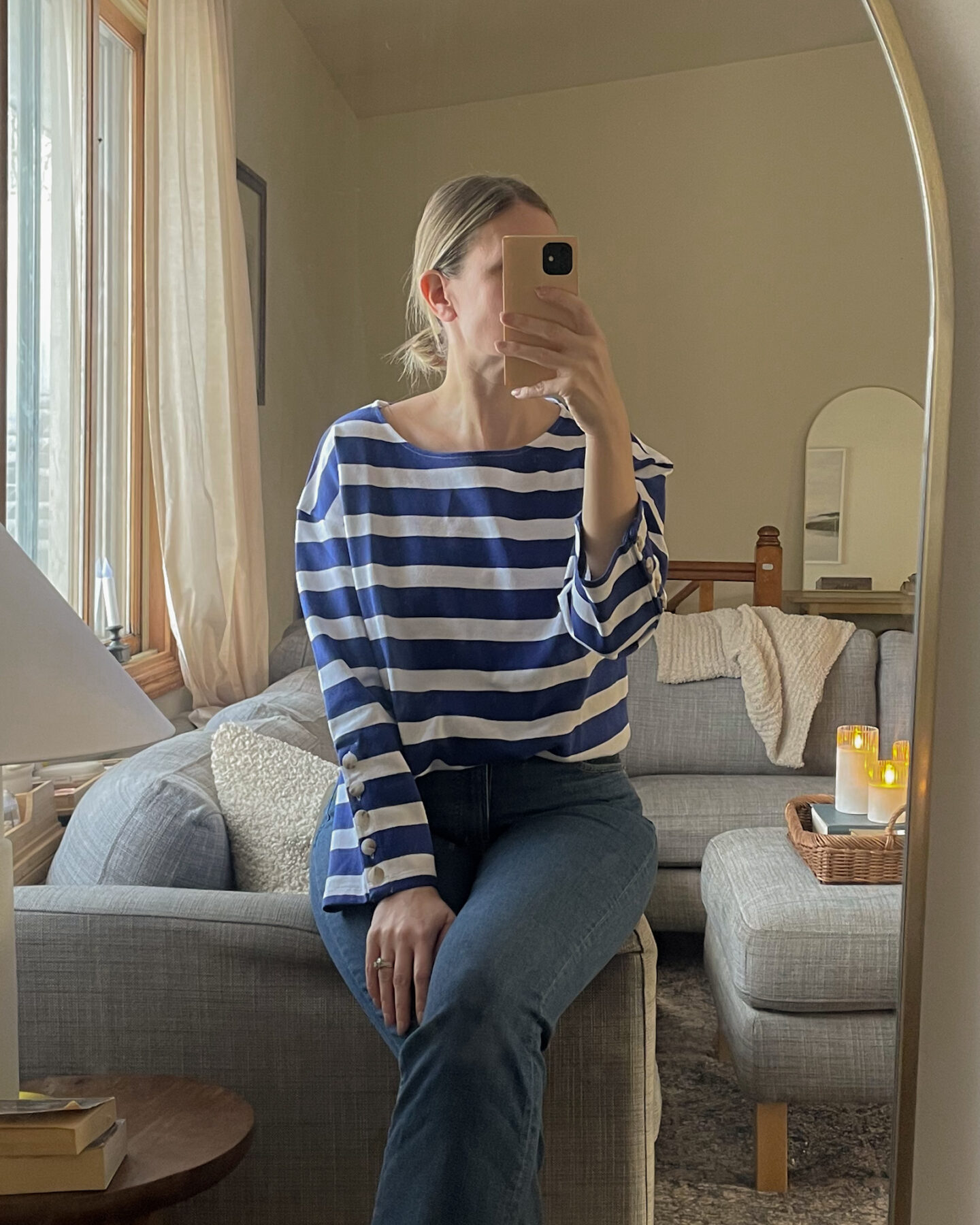 Karin Emily wears a striped tee from Sezane and a pair of dark wash jeans 