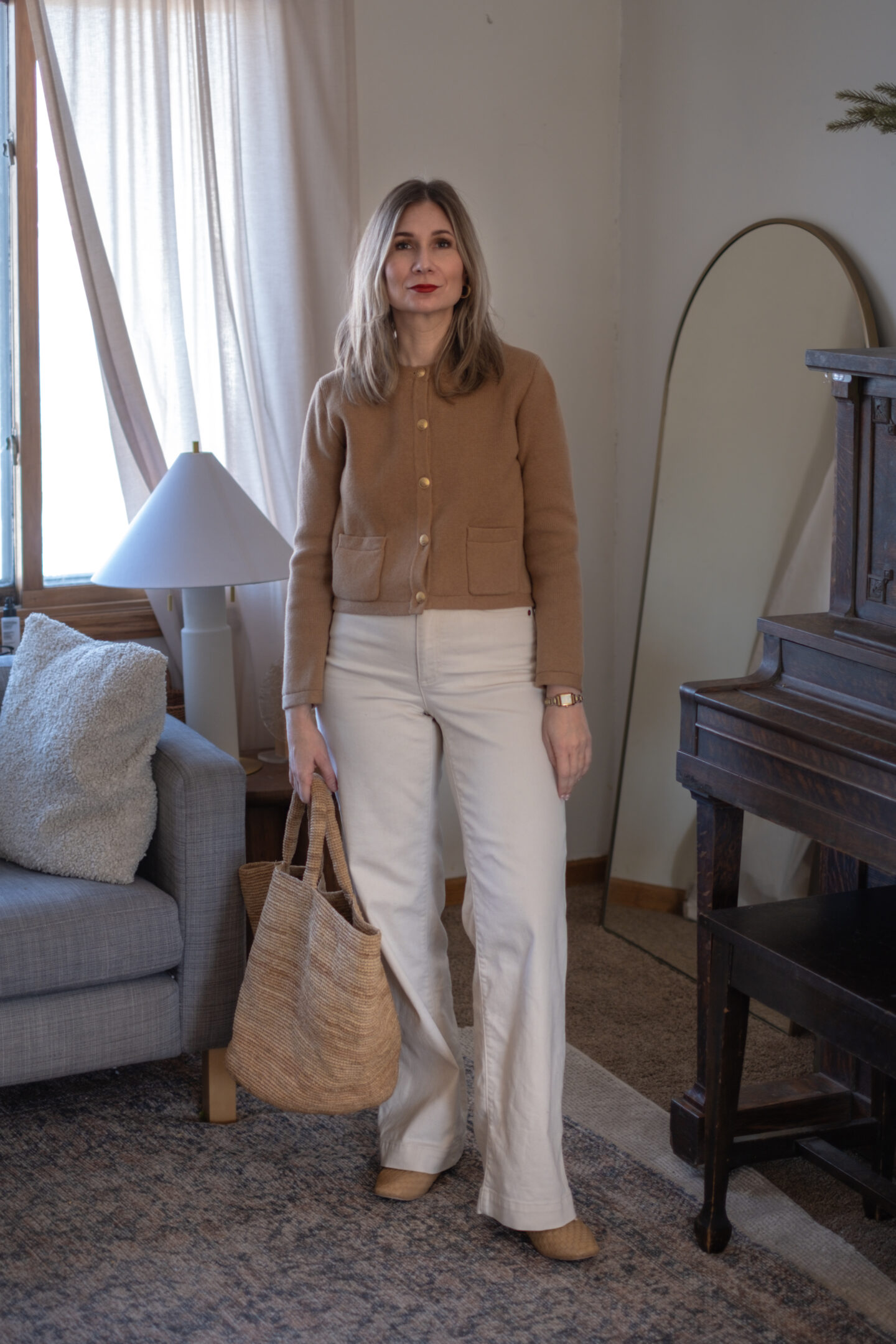 Karin Emily wears her white jeans for spring with a camel colored sweater blazer and Freda Salvador woven flats