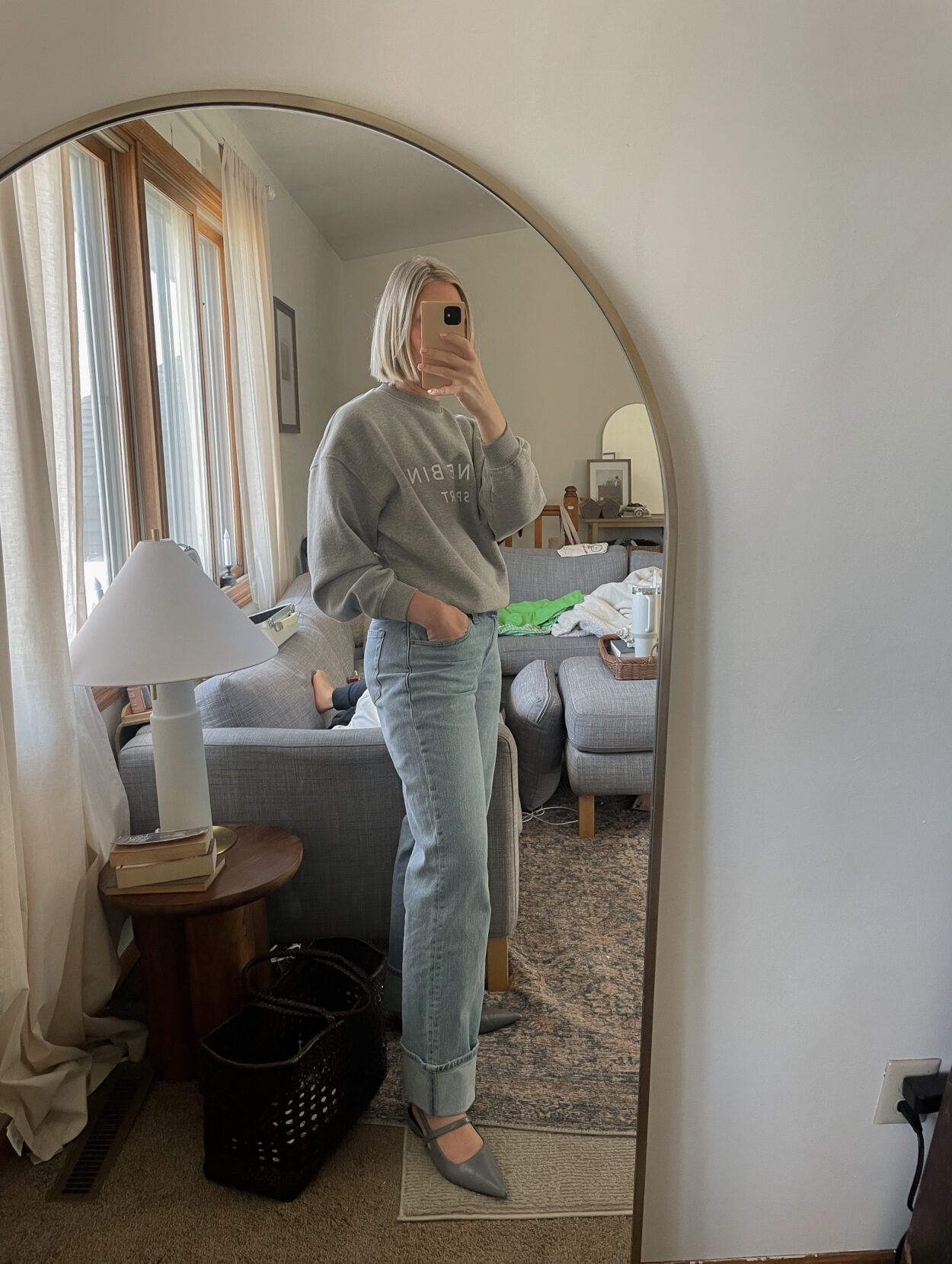 Karin Emily wears a daily spring outfit with a gray Anine Bing Sweatshirt, Baggy Cuffed Jeans, Red Adidas Gazelle Sneakers