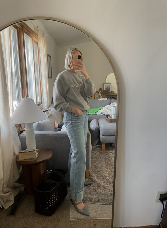 Karin Emily wears a daily spring outfit with a gray Anine Bing Sweatshirt, Baggy Cuffed Jeans, Red Adidas Gazelle Sneakers