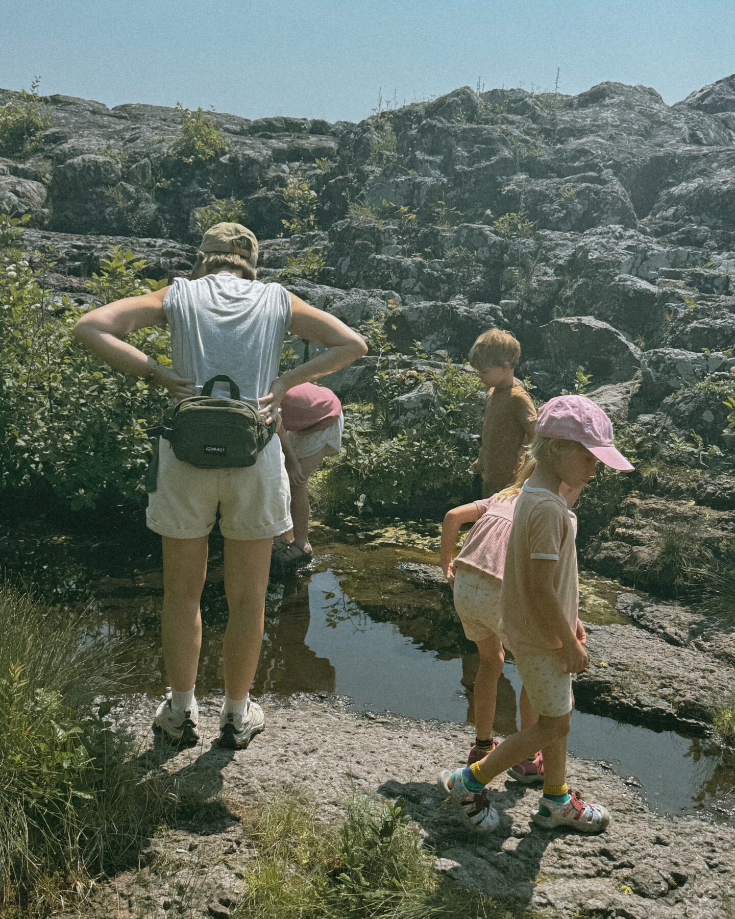 Karin Emily hikes with her kids on some cliffs in North Shore Minnesota wearing one of her athleisure summer uniforms 