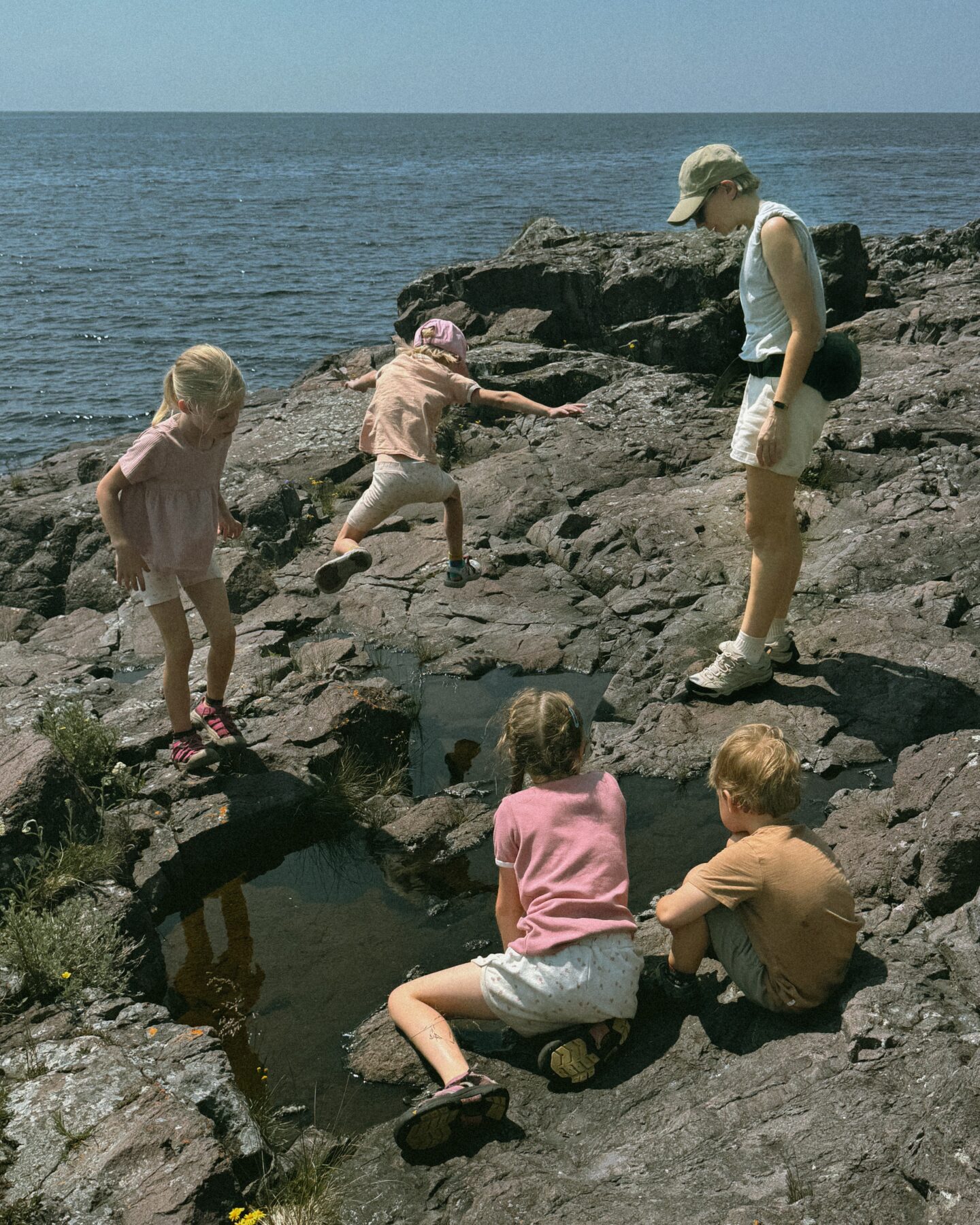 Karin Emily hikes with her kids on some cliffs in North Shore Minnesota wearing one of her athleisure summer uniforms 