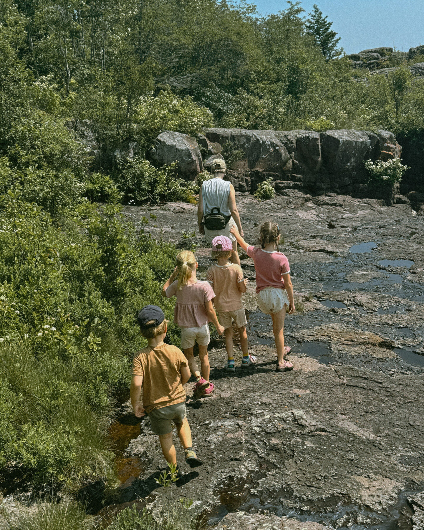 Karin Emily hikes with her kids on some cliffs in North Shore Minnesota wearing one of her athleisure summer uniforms 