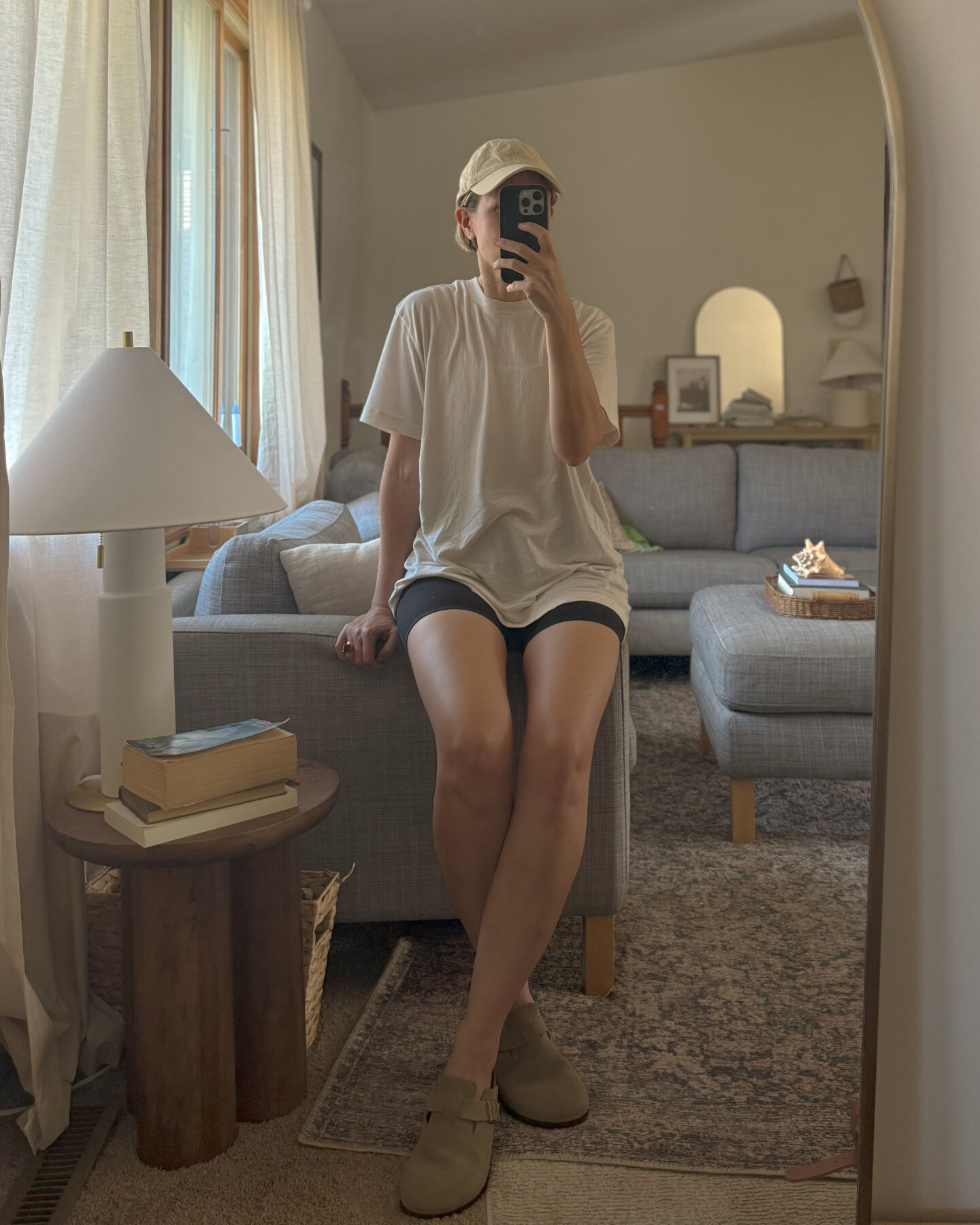 Karin Emily shares a mirror selfie in a warm weather athleisure outfit with bike shorts and an oversized t-shirt 