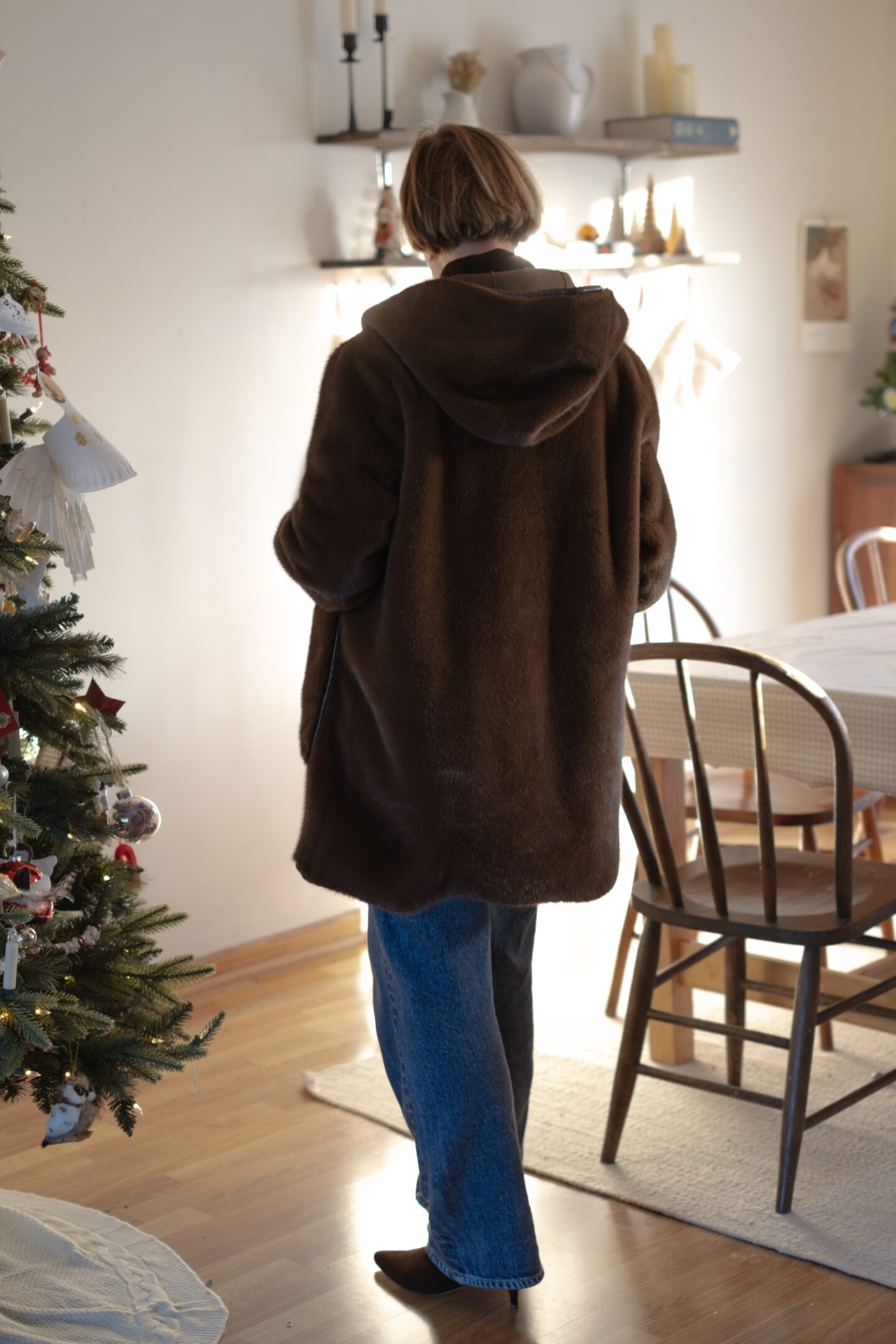 Karin Emily stands in her holiday decorated dining room and wears a chocolate brown monochrome outfit 