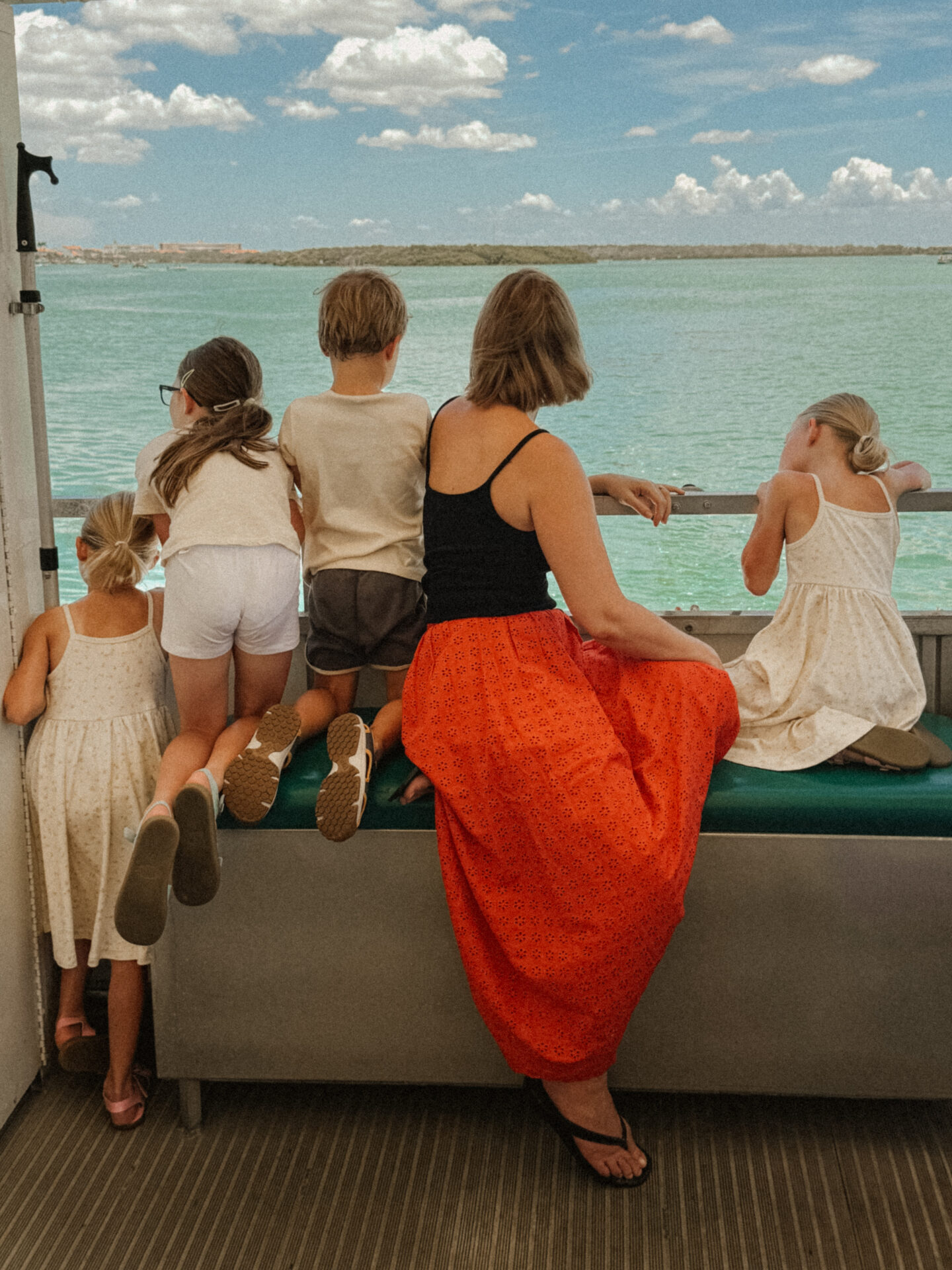 Karin Emily sits with her four children on a boat and look out into the ocean. in this blog post she talks about having a hysterectomy and what life is like with four neurodivergent children.